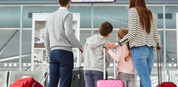 Family with children and suitcases at the airport ready for an airport transfer with Arrivals Star Taxis.